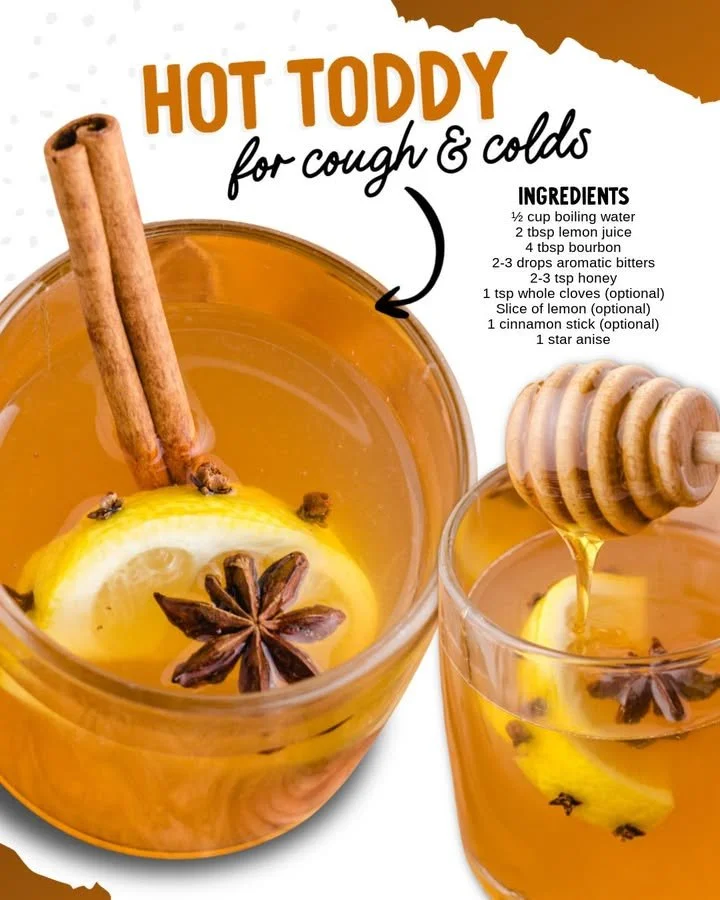 A warm Hot Toddy in a mug with lemon and cinnamon sticks