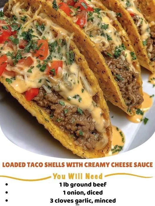 Loaded taco shells topped with creamy cheese sauce, perfect for a delicious meal.