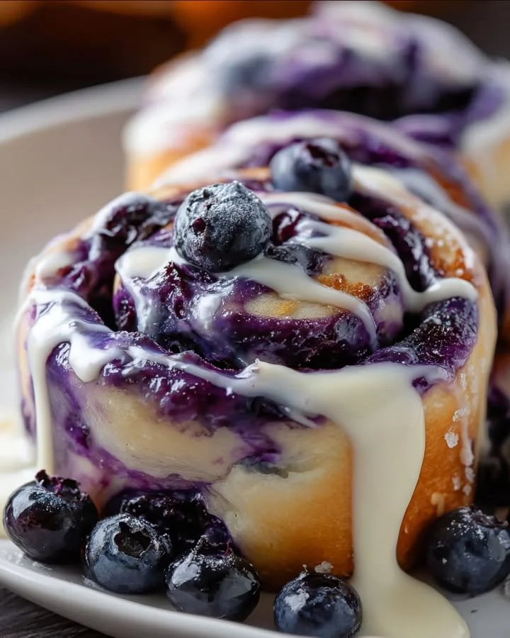 Delicious blueberry cheesecake rolls on a plate with fresh blueberries