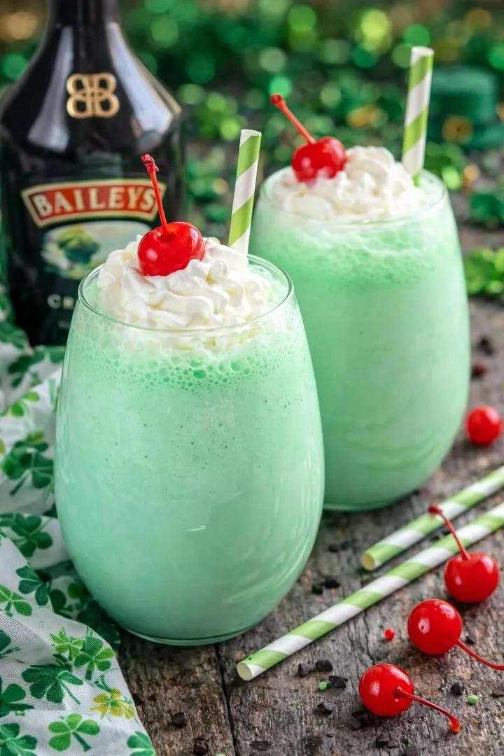 Boozy shamrock shake in a glass with a festive green color and whipped cream