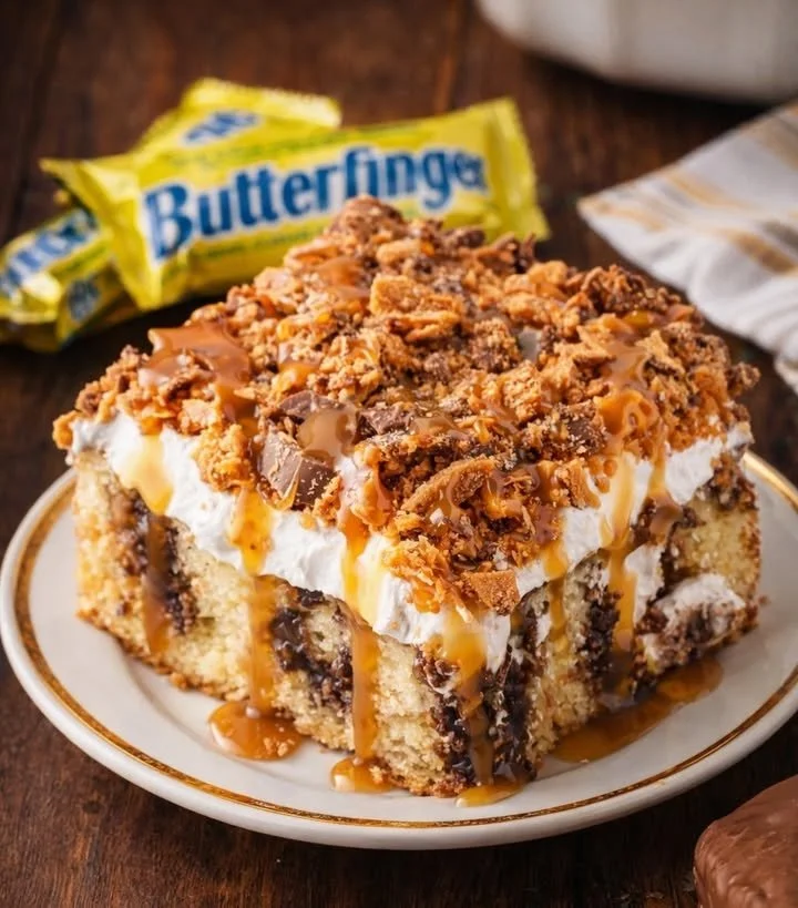 Delicious Butterfinger Poke Cake topped with peanut butter and chocolate drizzle
