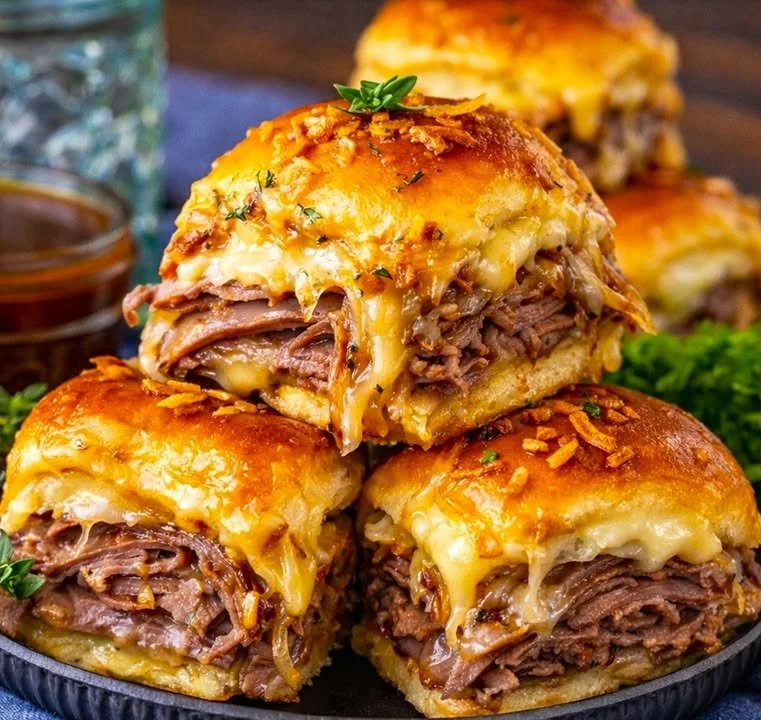 Delicious French Dip Sliders with beef and au jus on a platter