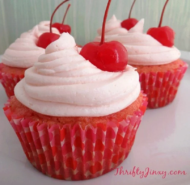 Delicious maraschino cherry cupcakes with vibrant red cherries on top.