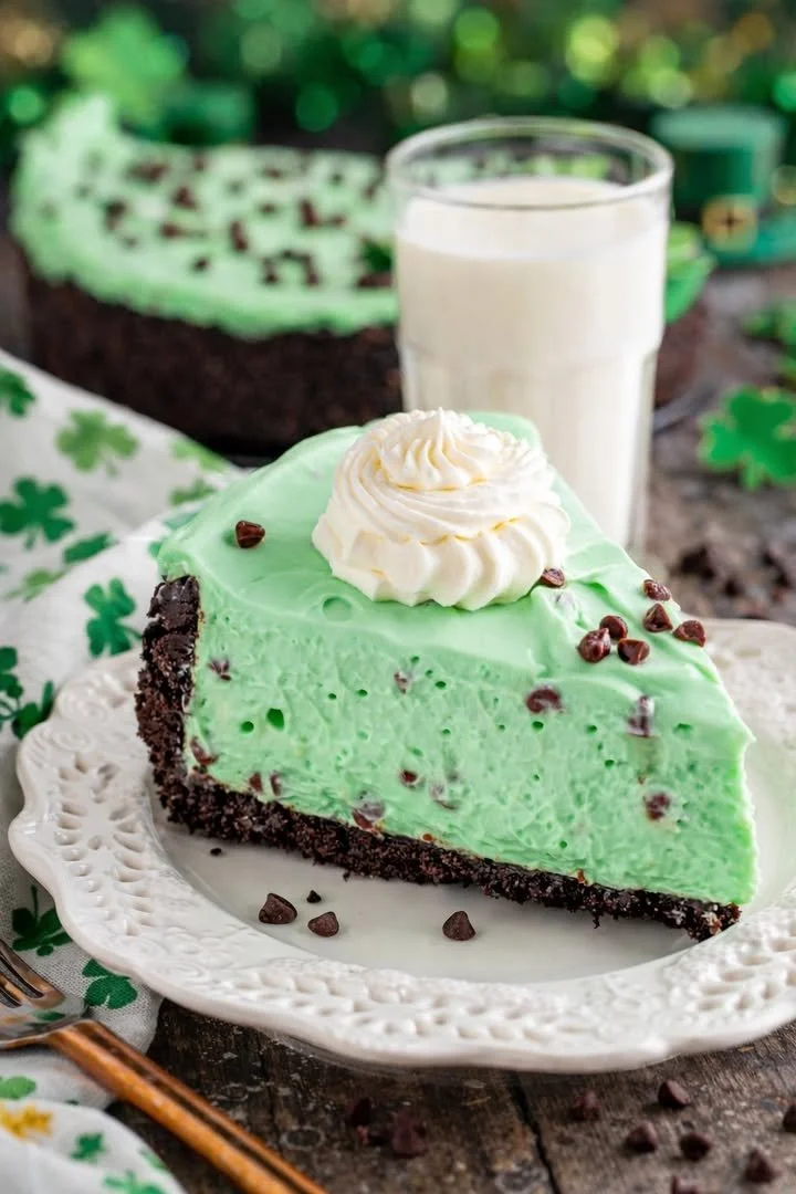 No Bake Mint Chocolate Chip Cheesecake served with a sprig of mint garnish